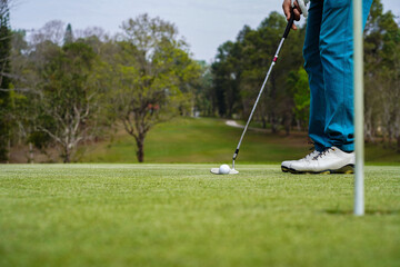 Golfer playing golf in the evening golf course, on sun set evening time. Man playing golf on a golf...