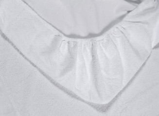 Mattress top corner with sewn-in elastic band for a good fit on the mattress and a comfortable sleep. White fabric for mockup overlays of any design. Home textile for the bedroom
