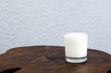A glass of milk is on the table. Wooden table
