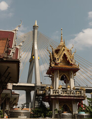 Obraz premium Bangkok, Thailand. Mar - 12, 2022 : Beautiful view of Buddhist thai temple with suspension bridge background can coexist perfectly. No focus, specifically.