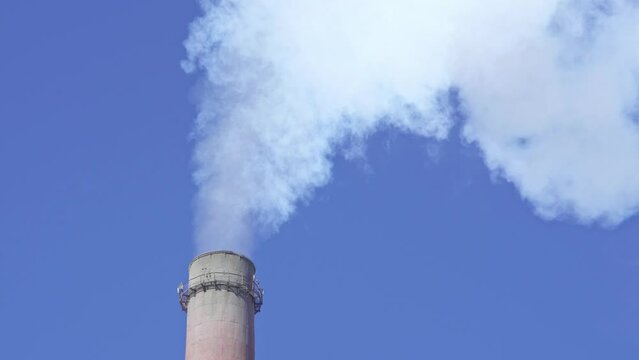 Industrial factory chimney is smoking the environment with carbon dioxide