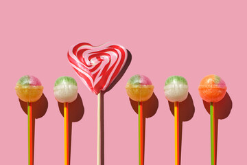 Colorful Set of Lollipops. pattern made with caramel on a stick on bright pink background.  creative pattern.