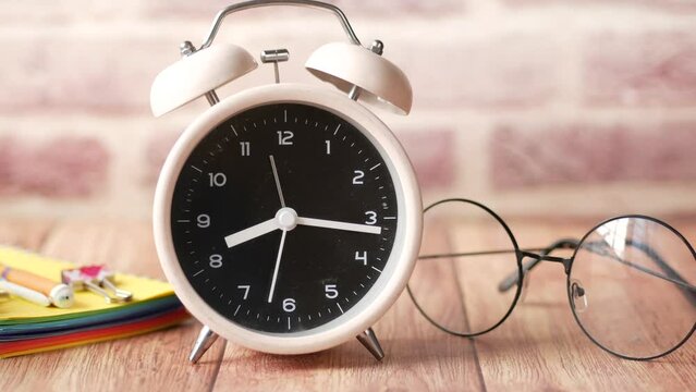 notepad, eyeglass and clock on table close up