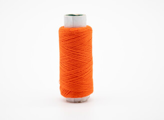 orange color yarn on spool, yarn on tube, cotton, wool, linen thread, isolate on white background