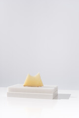 Trozo de queso manchego de oveja curado mordido sobre una mesa blanca. Aperitivo español	 - obrazy, fototapety, plakaty
