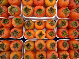 Persimmon fruits on a farmers market stall in the Aegean coastal town Yalikavak, Bodrum, Turkey.    