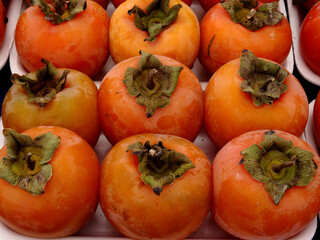 Persimmon fruits on a farmers market stall in the Aegean coastal town Yalikavak, Bodrum, Turkey.    