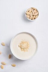 Crema de almendras, sopa fría española. Ajo blanco de Málaga con almendras en un recipiente blanco sobre una mesa blanca. Vista superior	