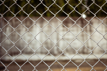 The image of a white barbed wire fence and a wall is used for the background illustration.