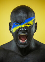 Flag of Ukraine painted on a face of soldier. War between Ukraine and Russia