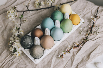 Stylish Easter eggs and cherry blossoms on rustic linen cloth. Happy Easter!  Natural dyed colorful...