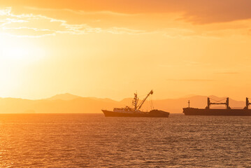 Obraz premium Beautiful sunset on the coast with several vessels 