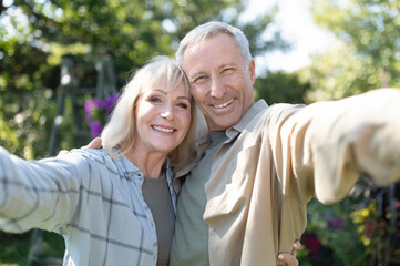 Happy senior spouses making selfie, hugging, smiling to camera, spending time together in their...