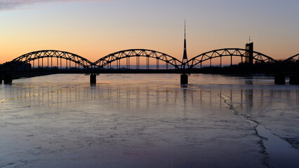 Dawn over the Daugava River in spring with the railway bridge as a backdrop