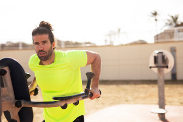 Young muscle man training outside. Fit handsome man doing exercise.