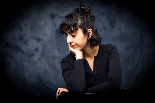 Profile Of A Young Girl Sitting In A Black Chair.