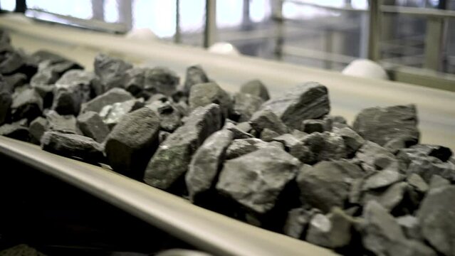 The movement of iron ore on the conveyor. Part of the technological process of mineral processing. Raw iron ore before processing. Raw material for metallurgy.