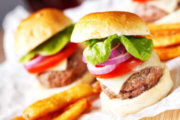 Mini hamburgers with tomato, salad and cheese on wooden board