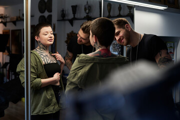 Caucasian man and woman checking what the tattoo looks like