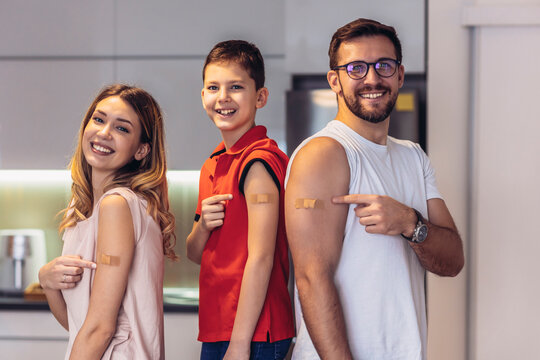 Coronavirus Vaccination. Vaccinated Family Of Three With Adhesive Bandage On Arms Posing At Home After Getting Covid-19 Vaccine
