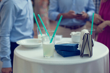 Mesa de limonada fresca en un catering con personas sirviéndose refrescos de limón en vasos