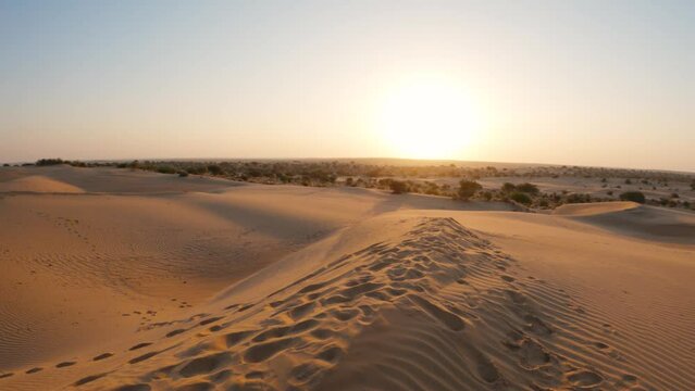 4K Shot of Sam sand dunes in the evening at Thar desert at Jaisalmer in Rajasthan, India. View of the sunset at the sand dunes in the desert. Desert background.