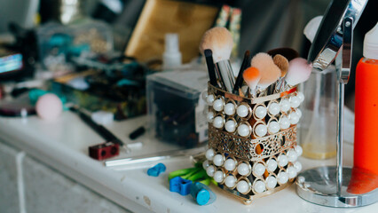 Makeup items, brushes, mirror, eyeliner. Copy space.