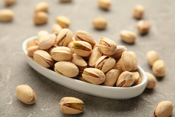 Pile of Pistachios ob white bowl isolated on white background.