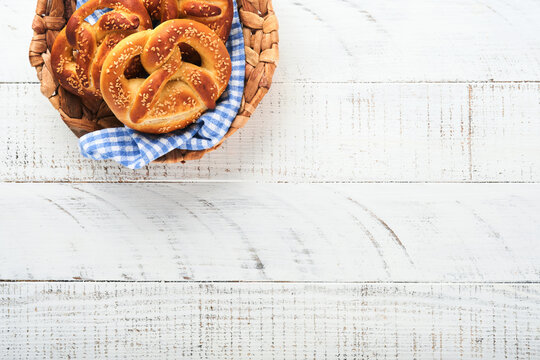 Bavarian pretzels. Oktoberfest food menu, traditional salted pretzels over old white wooden background. Top view with space for text. Oktoberfest theme