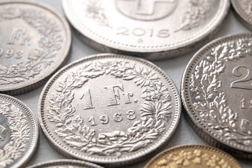 Swiss franc coins on white surface. Value of the Swiss Franc and exchange rate trend.
