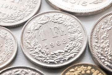 Swiss franc coins on white surface. Value of the Swiss Franc and exchange rate trend.
