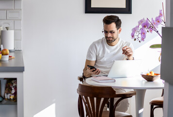 Man working at home using laptop.