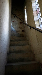 A dark narrow staircase leading to a church tower