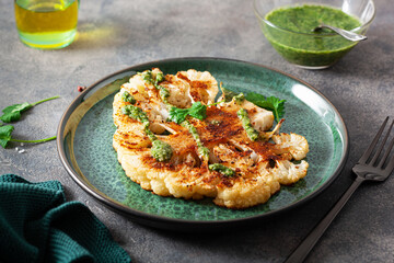 cauliflower steaks with herb sauce and spice. plant based meat substitute