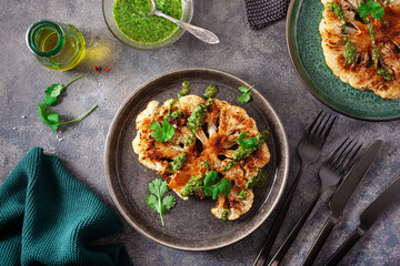 cauliflower steaks with herb sauce and spice. plant based meat substitute