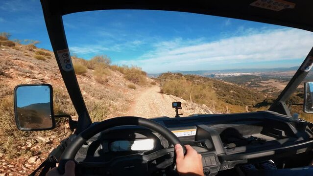 Point of view driving a buggy UTV ATV Can-am polaris on desert off-road in Ronda, Spain, on a sunny day . POV man having fun riding a ATV off-road