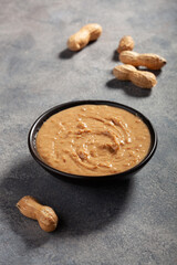 smooth peanut butter in bowl on gray background