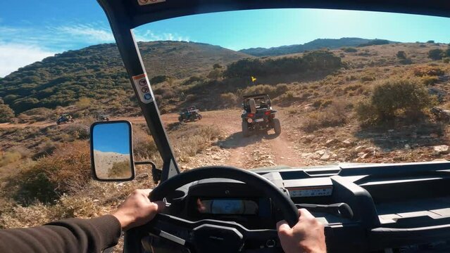 Point of view driving a buggy UTV ATV Can-am polaris on desert off-road in Ronda, Spain, on a sunny day . POV man having fun riding a ATV off-road