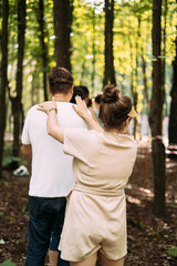 Team building exercise. People stand behind each other and hold their shoulders with their hands. Back view