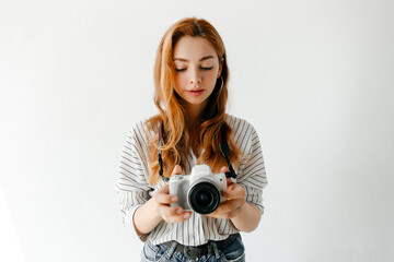 Fototapeta premium Young woman photographer looking at the live view on her modern camera, woman is enjoying the process