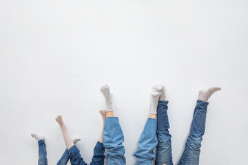 legs of parents and children in socks and blue jeans close-up. The concept of happy and equal relationships in the family