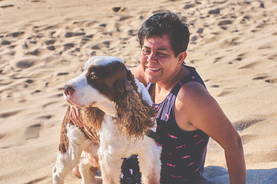 Adult woman on the beach with her pet. free time, retirement.