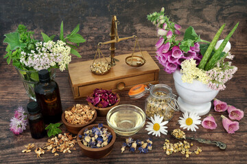 Flowers and herbs with essential oil bottles used in aromatherapy treatments. Alternative herbal...