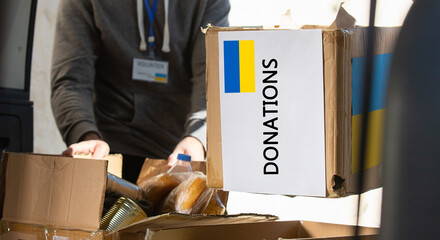 Box with donation clothes and food for ukrainian refugees suffering from war. Charity and Helping...