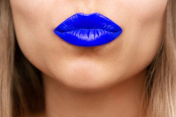 Cropped shot of a young beautiful caucasian blonde woman blowing a kiss with her lips with bright...