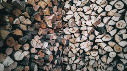 Background of a pile of wooden firewood neatly placed on the wall