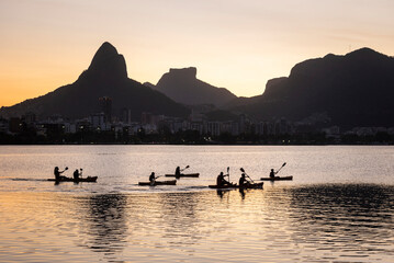 Beautiful view to people kayaking on city lake with mountains