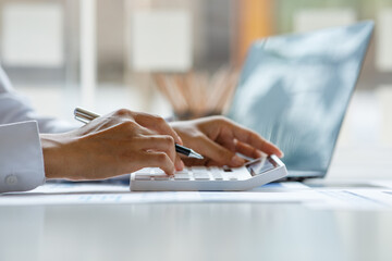 Close up of businesswoman Accounting using calculating income-expenditure and analyzing real estate...
