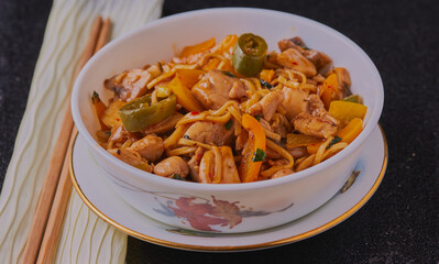 Chicken noodles with vegetables in a bowl.