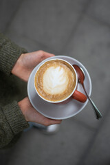 Manos sujetando un delicioso café caliente.